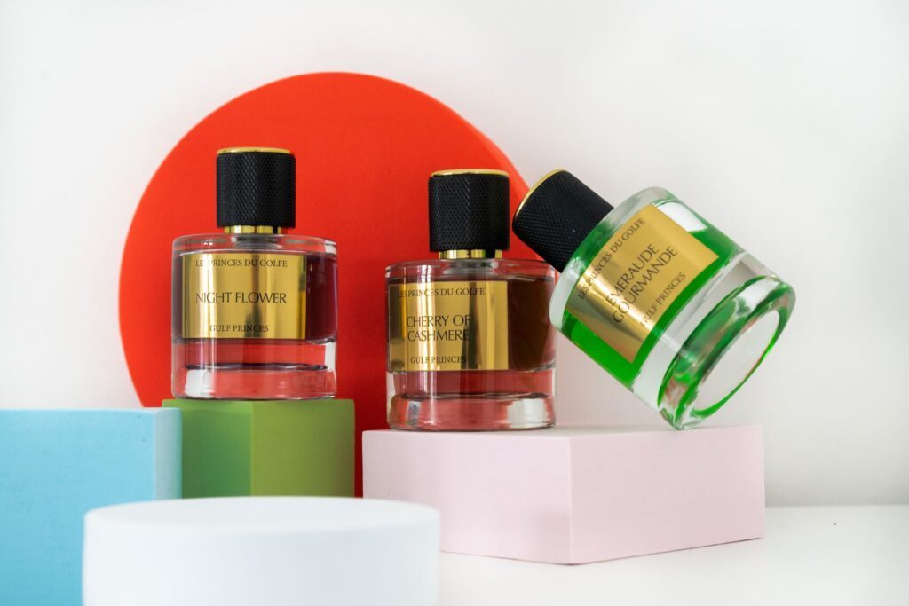 Une photo illustrant trois flacons de parfum de niche. Emeraude Gourmande, Cherry of Cashmere et Night Flower. 