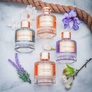 la collection des parfums des princes du golfe made in dubaï posé sur du marbre et a coté de fleurs