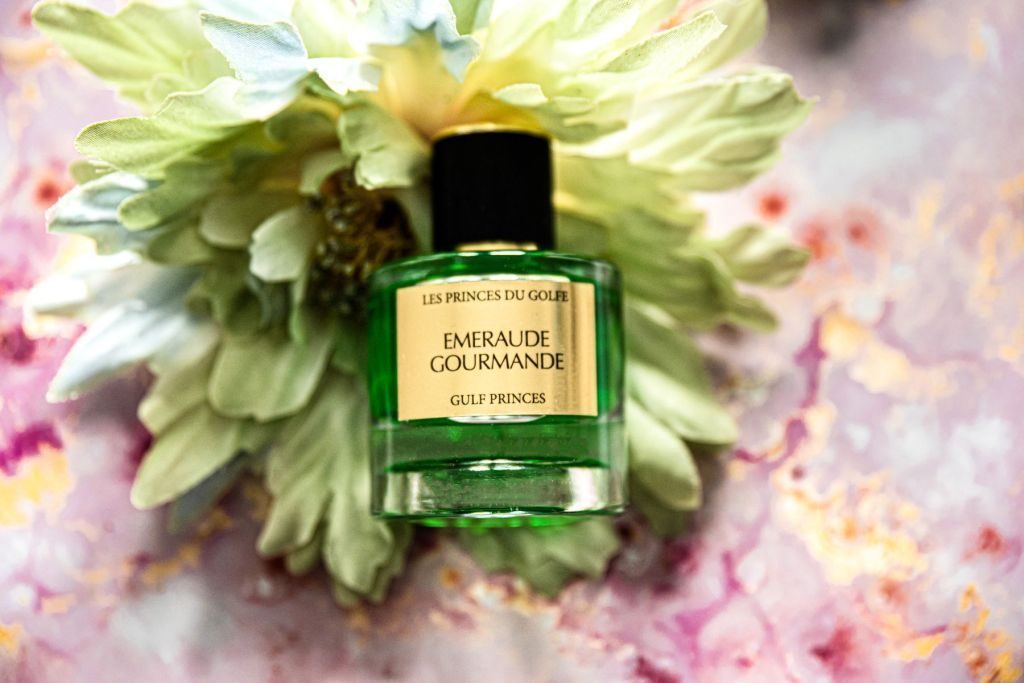 Le parfum Fruité Emeraude Gourmande posé sur une fleur.