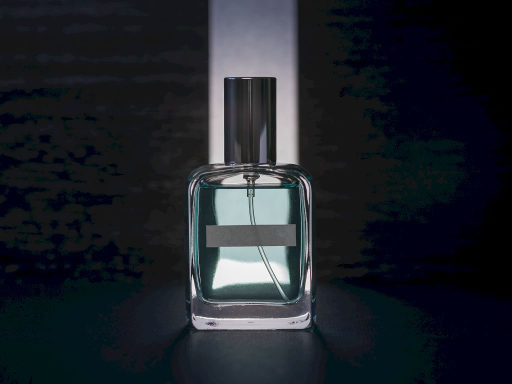 Un flacon de parfum simple sur fond noir avec une lumière blanche.